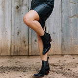 Women wearing black botin wih suede overlayed leather. Botin angled to the right