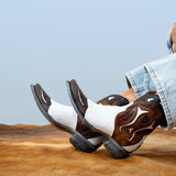Brown and white cowgirl boots with blue jeans on a cowhide surface and light blue background
