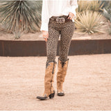 Women wearing a suede dijon tall boot with leather overlayed and studs.