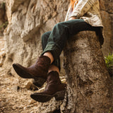 Women wearing a whiskey botin with a geometric pattern embroidered on the shaft and studs on the heel. Angled to the left